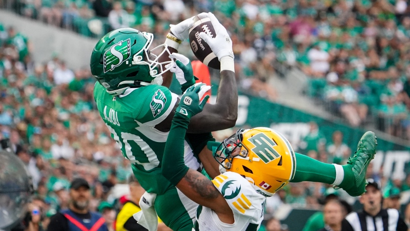 Saskatchewan Roughriders receiver Ajou Ajou (80) catches the football for a touchdown as Edmonton Elks defensive back Devodric Bynum (16) defends during the second half of CFL football action in Regina, on Saturday, August 3, 2024. THE CANADIAN PRESS/Heywood Yu