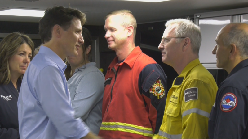 Alberta Premier Danielle Smith, left, and Prime Minster Justin Trudeau, centre, speak with officials from the Jasper wildfire unified comand centre in Hinton, Alta., on Aug. 5, 2024. (Sean McClune / CTV News Edmonton) 