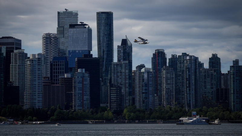 A Harbour Air seaplane takes off past office and condo towers as a boat refuels at a floating Chevron station on the water, in Vancouver, on July 25, 2024. THE CANADIAN PRESS/Darryl Dyck