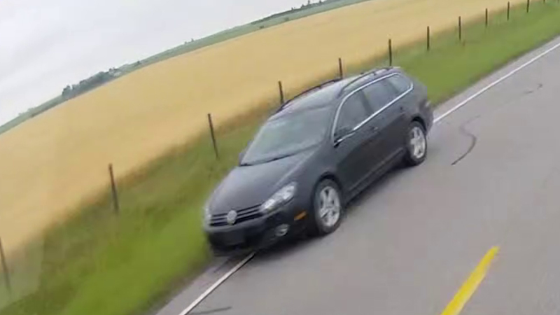 A dark grey Volkswagen Golf Sportwagon, potentially between 2013 and 2015, captured on dash-cam footage near the scene of a shooting at Range Road 282 and Township Road 250 on Aug. 6, 2024. (Supplied: RCMP) 