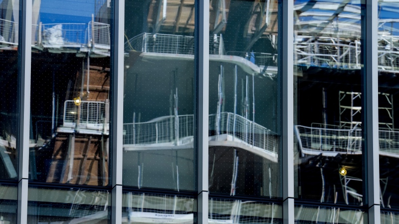 A condo construction site is reflected in the window in downtown Toronto on May 25, 2023. (Chris Young / The Canadian Press)