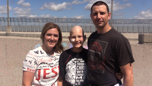 Felix Ward (centre) – a 12-year old with cancer – poses for a photo with his parents Priscilla and Brian at London Health Sciences Centre on Aug 10, 2024. (Brent Lale/CTV News London)