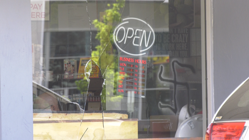 A broken window and a swastika painted at Milano Pizzeria in Ottawa on Aug. 11, 2024. (Sam Houpt/CTV News Ottawa)