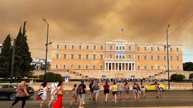 Smoke from wildfires is seen above the Greek parliament building in central Athens, Sunday, Aug. 11, 2024, after a blaze northeast of the capital forced evacuations in the area. (AP Photo/Derek Gatopoulos)