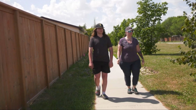 Phoenix Morpheus walks with his mom RainShyne a day after he was hit by a vehicle while riding his bike in River Park South on Aug. 12, 2024. (Alexandra Holyk/CTV News Winnipeg)