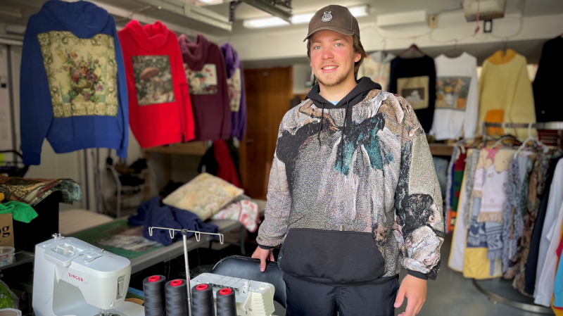 Evan Carr poses with products for his company, the Travelling Gallery, on August 23, 2024. (Spencer Turcotte/CTV News)