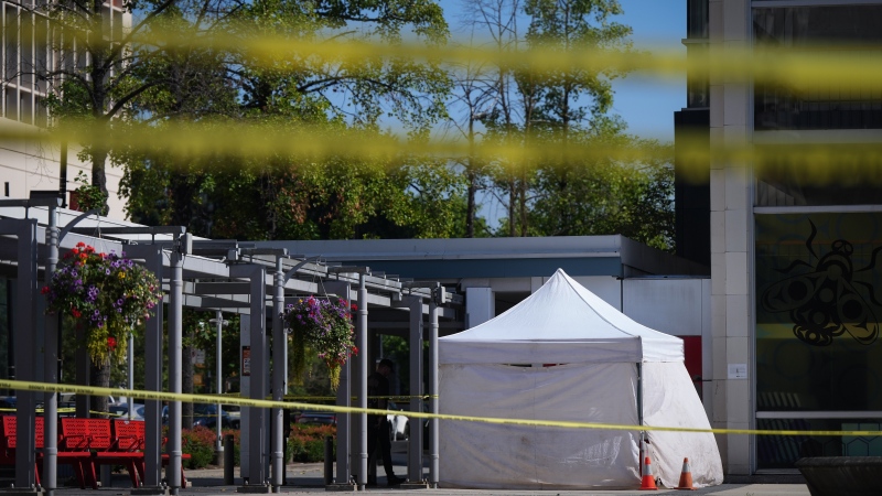 A police officer stands near an evidence tent outside the Queen Elizabeth Theatre in Vancouver, on Wednesday, September 4, 2024. Vancouver police say a man has been arrested in connection with two serious incidents that happened between 7:30 a.m. and 7:45 a.m. in the downtown area and that the investigation is ongoing. THE CANADIAN PRESS/Darryl Dyck