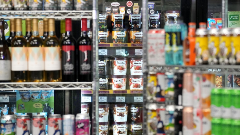 Beer cans are stacked as props in front a display of ice cream, at a press availability attended by Ontario Premier Doug Ford at a convenience store in Toronto, Thursday, Dec. 14, 2023. THE CANADIAN PRESS/Chris Young