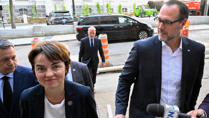 Minister Christine Frechette, left, walks towards the Lieutenant Governor's office to be sworn in as Minister of the Economy and Energy on Thursday, September 5, 2024, in Quebec City. Fréchette will be replaced as Immigration Minister by Jean-François Roberge, right. (The Canadian Press/Jacques Boissinot)