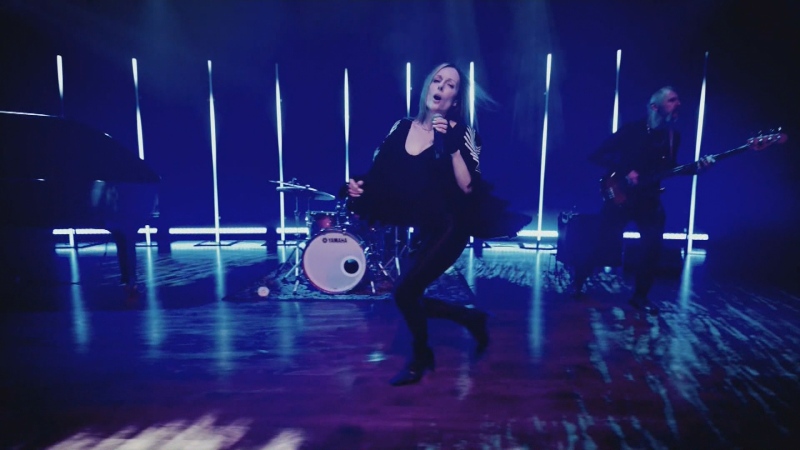 Dartmouth, N.S., singer-songwriter Christina Martin dances across a stage, microphone in hand, with her band behind her.