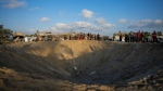 Palestinians look at the destruction after an Israeli airstrike on a crowded tent camp housing Palestinians displaced by the war in Muwasi, Gaza Strip, Sept. 10, 2024. (AP Photo/Abdel Kareem Hana)