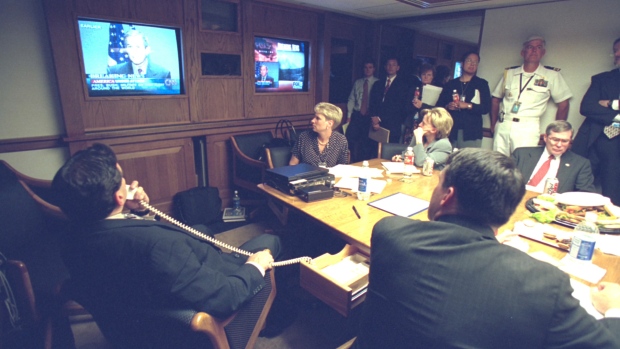 Tense moments inside the United States' President's Emergency Operations Center (PEOC) as terror attacks strike targets inside the country on Sept. 11, 2001. <br> <br> Vice President Dick Cheney speaks with a staff member. (The U.S. National Archives)