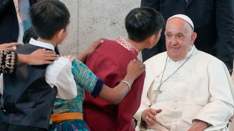 Pope Francis is welcomed by dancing children at Singapore Changi International Airport on Sept. 11, 2024. (Gregorio Borgia / AP Photo)