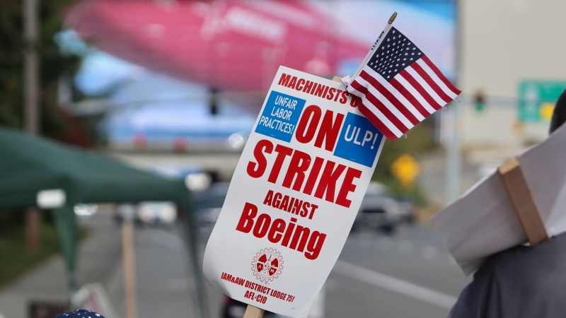 A strike sign is waved on the union machinist picket line near Boeing's factory in Everett, Washington, Thursday, Sept. 19, 2024. (Manuel Valdes / AP Photo)