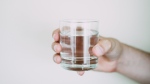 A person holds a glass of water. (Lisa Fotios/Pexels) 