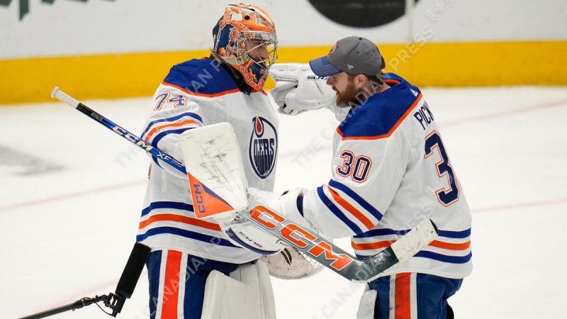 Edmonton Oilers goalies Stuart Skinner, left, and Calvin Pickard celebrate their team's win on May 31, 2024, over the host Dallas Stars in Game 5 of the Western Conference finals. (Julio Cortez/Associated Press)