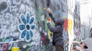 Artists gathered in a downtown Timmins laneway Friday to paint a mural depicting scenes of nature. (Lydia Chubak/CTV News Northern Ontario)