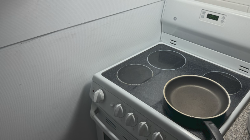 A taped cardboard wall is seen next to a stove in a Vancouver housing unit. (Credit: Roman Karoly) 