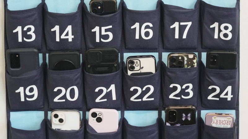 A phone holder hangs in a classroom at Delta High School, Friday, Feb. 23, 2024, in Delta, Utah. AP/Rick Bowmer