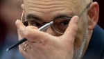 Parliamentary Budget Officer Yves Giroux adjusts his glasses as he waits to appear before the Senate Committee on National Finance, Tuesday, October 17, 2023 in Ottawa. (Adrian Wyld / The Canadian Press)