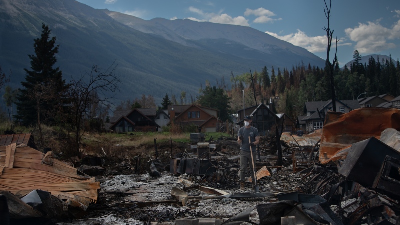 A homeowner digs in the ashes of their home as some return to Jasper, Alberta on Monday, Aug. 19, 2024. (Amber Bracken / The Canadian Press) 