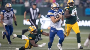 Winnipeg Blue Bombers quarterback Zach Collaros (8) runs as Edmonton Elks' Elliott Brown (41) misses the tackle during second half CFL action in Edmonton, on Saturday September 21, 2024. (Jason Franson/The Canadian Press)