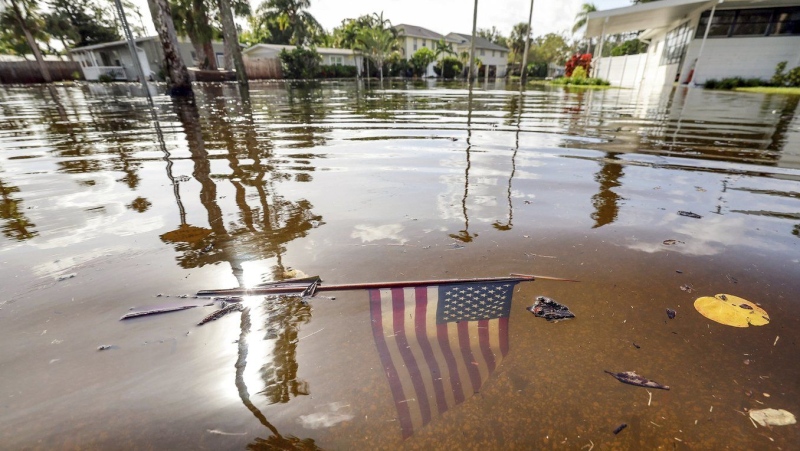 An American flag sits in the floodwaters from Hurricane Helene in the Shore Acres neighbourhood Friday, Sept. 27, 2024, in St. Petersburg, Fla. (AP Photo/Mike Carlson)