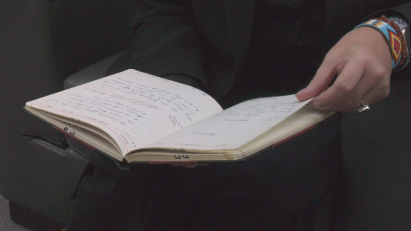 Shannon Cornelsen looks through one her grandfather's journals documenting his time as an Indian Affairs between 1954 and 1980. (Nahreman Issa/CTV News Edmonton)