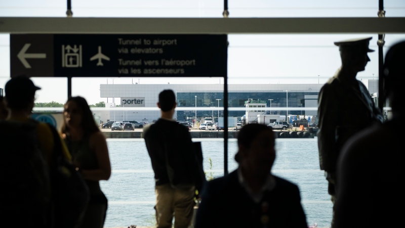 Porter staff direct travellers at Billy Bishop Airport in Toronto on Friday, July 19, 2024. Porter Airlines suspended flights until at least noon as a global tech outage affected flights at the airline. THE CANADIAN PRESS/Christopher Katsarov 