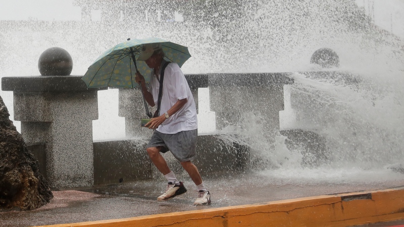 A man runs away from waves when he was walking along the shore in Kaohsiung, Southern Taiwan, Wednesday, Oct. 2, 2024, as Typhoon Krathon is expected to hit the area. (AP Photo/Chiang Ying-ying)
