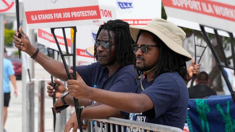 Dockworkers from Port Miami display signs at a picket line, Thursday, Oct. 3, 2024, in Miami. (Marta Lavandier / AP Photo)