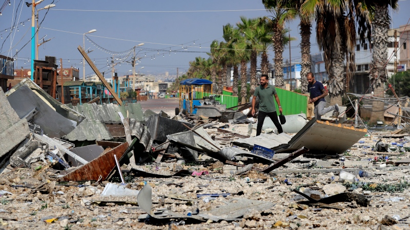 People walk on debris of a seaside coffee shop that was hit by an Israeli airstrike in Ghaziyeh town, south Lebanon, Sunday Oct. 6, 2024. (Mohammed Zaatari / AP Photo)