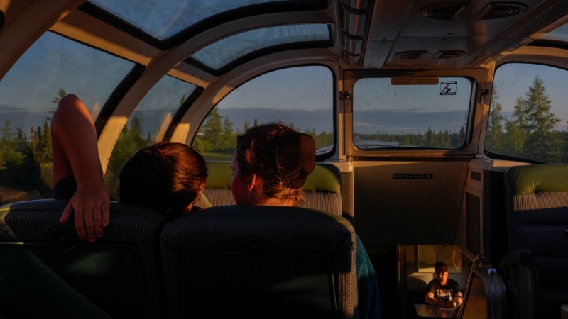 Passengers relax inside the skyline car as the sun sets Thursday, Aug. 8, 2024, between Churchill and Gilliam, Manitoba. (AP Photo/Joshua A. Bickel)