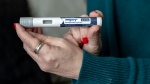 Donna Cooper holds up a dosage of Wegovy, a drug used for weight loss, at her home in Front Royal, Va., on March 1, 2024. (Amanda Andrade-Rhoades / AP Photo)