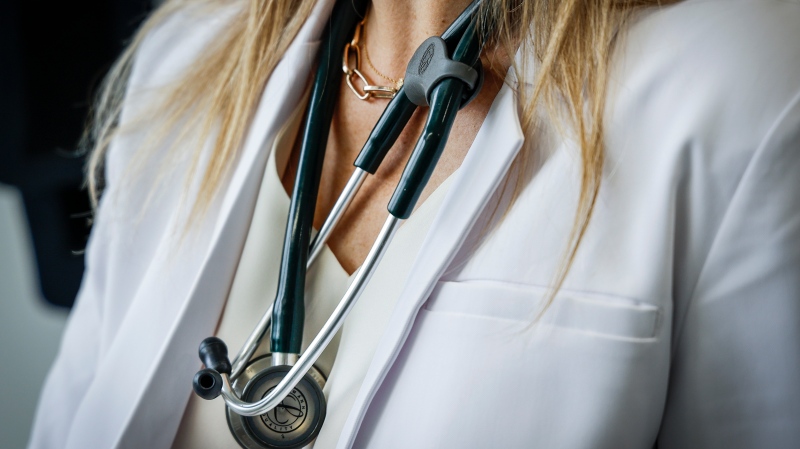 A doctor wears a lab coat and stethoscope in an exam room at a health clinic in Calgary, Friday, July 14, 2023.THE CANADIAN PRESS/Jeff McIntosh