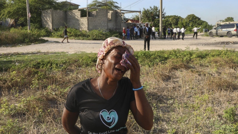 A neighbour cries during the funeral of Jean Louis Jeune Gracien, who was killed during an attack by armed gangs, in Pont-Sonde, Haiti, Tuesday, Oct. 8, 2024. (AP Photo/Odelyn Joseph)