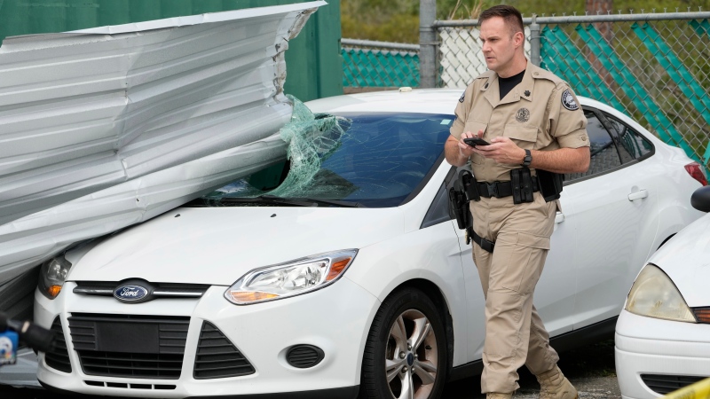 Florida Highway Patrol Regional Commander Major Matthew Williams walks past a car damaged by a tornado spawned by Hurricane Milton at the St. Lucie County Sheriff's parking facility, Thursday, Oct. 10, 2024, in Fort Pierce. (Wilfredo Lee / AP Photo)