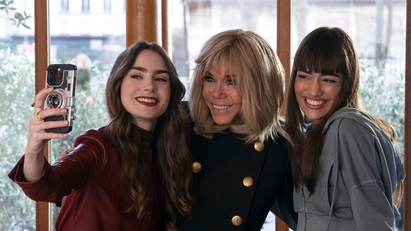 Brigitte Macron (centre) appeared in an episode where she posed for a selfie with Lily Collins as Emily (left) and Thalia Besson as Genevieve (right). (Netflix via CNN Newsource)