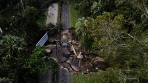 A bridge going over a small creek is seen damaged by Hurricane Milton, Friday, Oct. 11, 2024, in Riverview, Fla. The road is the only access point into a community. (AP Photo/Julio Cortez)