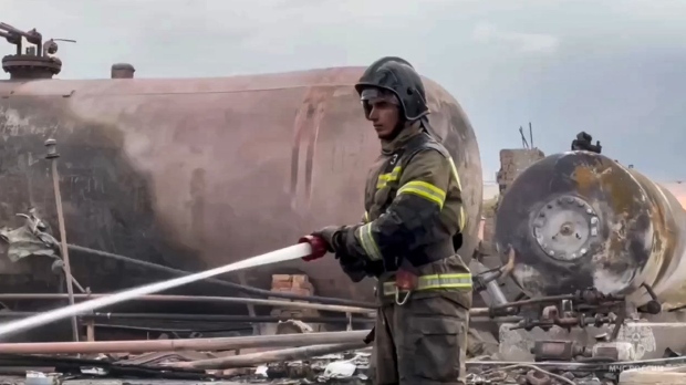 In this photo taken from video released by Russian Emergency Ministry Press Service on Saturday, Oct. 12, 2024, a firefighter extinguishes a large fire after an explosion at a gas station in Grozny, the capital of Chechen republic of Russia, which killed at least four people. (Russian Emergency Ministry Press Service via AP)