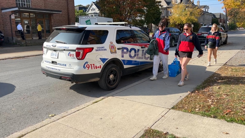 Students at Queens University walking by a Kingston Police vehicle on homecoming weekend. (Jack Richardson/ CTV News Ottawa)