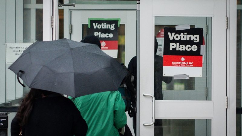 People walk into a polling station to vote on election day in Vancouver, on Saturday, October 19, 2024. Polls are now open in British Columbia, where voters in today's provincial election face a choice that would have been unthinkable just a few months ago. THE CANADIAN PRESS/Ethan Cairns