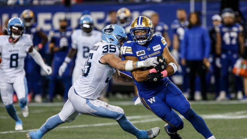 Winnipeg Blue Bombers' Nic Demski (10) avoids a tackle by Toronto Argonauts' Isaac Darkangelo (35) during second half CFL action in Winnipeg Friday, October 11, 2024. (John Woods/The Canadian Press)