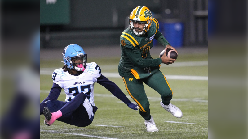 Edmonton Elks quarterback Tre Ford evades a tackle from Toronto Argonauts' Kenneth George Jr. during first half CFL action in Edmonton, on Friday October 25, 2024. THE CANADIAN PRESS/Larry Wong