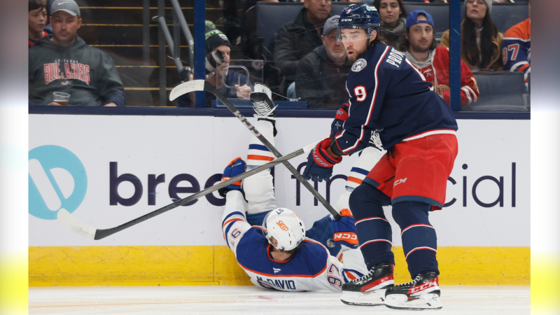 Columbus Blue Jackets defenceman Ivan Provorov, right, knocks Edmonton Oilers star Connor McDavid to the ice during the first period of NHL action on Oct. 28, 2024, in Columbus, Ohio. (Jay LaPrete/Associated Press)