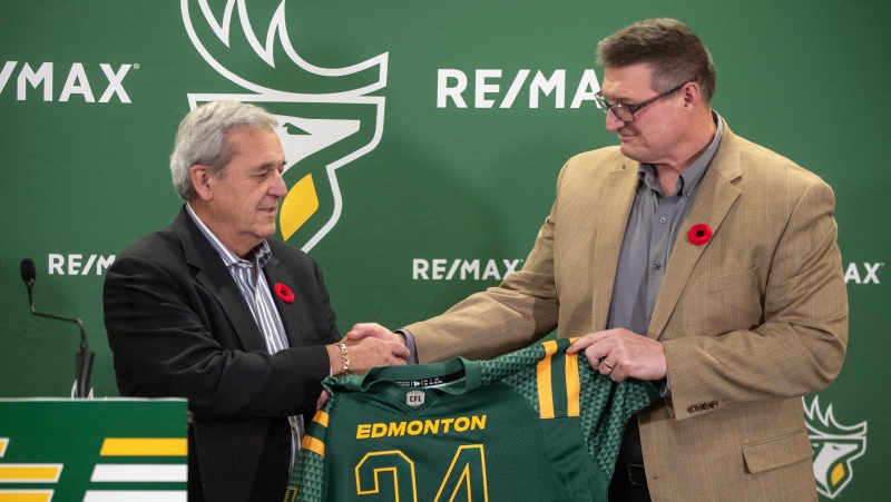 Edmonton Elks Outgoing President and CEO, Rick LeLacheur, left shakes hands with the new President and CEO Chris Morris during a press conference in Edmonton, on Thursday Oct.31, 2024. (Jason Franson/The Canadian Press)