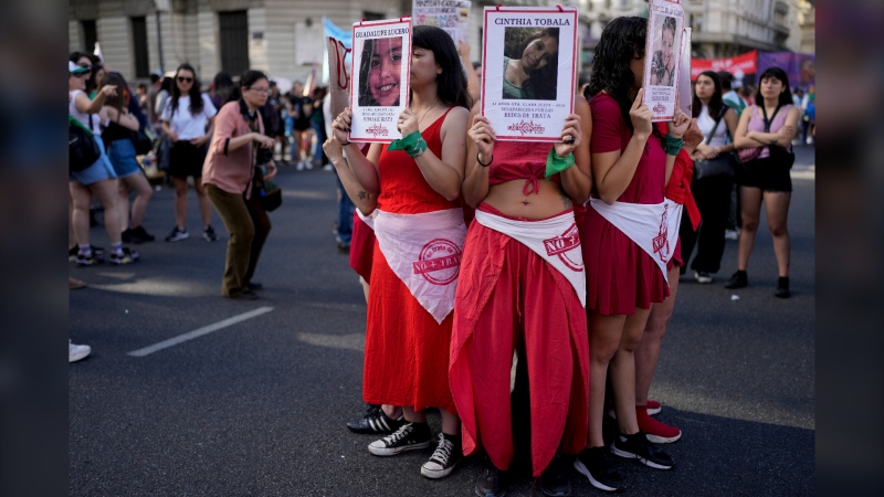 Protesters hold photos of human trafficking victims in Buenos Aires, Argentina on Nov. 25, 2023. (Natacha Pisarenko / AP Photo)