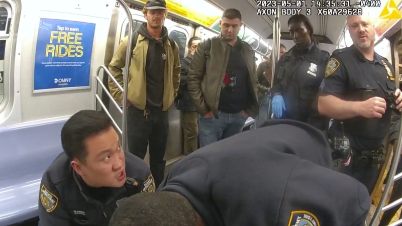 Daniel Penny, standing at left, looks on as officers attempt to revive Jordan Neely on May 5, 2023. (New York City Police Department via AP)