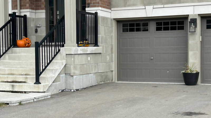 Bullet holes are visible in the garage door of a home on Mumberson Street in Cookstown, Ont., on Tues., Nov. 5, 2024. (CTV News/Rob Cooper)