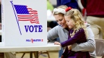 Kate Aurandt-Gribbler holds her daughter, Olivia Gribbler, 3, as she votes at a polling place in Johnstown, Pa., on Nov. 5, 2024. (Thomas Slusser / The Tribune-Democrat via AP)